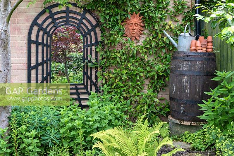 Angled mirror on wall giving illusion of larger garden