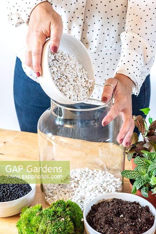 Planting a terrarium. Step 1: pour 1cm layer of alpine gravel into the base of jar.