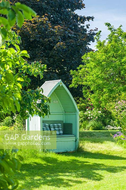 Pale green painted wooden garden arbour