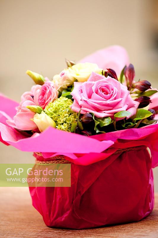 Gift wrapped arrangement of Roses, Hydrangea, Viburnum and Tulips