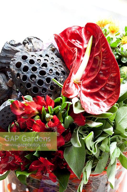 Close up detail of Vase filled with Alstroemeria, Carthamus, Celosia, Roses, dried Lotus flower, Anthurium, Allium, Eryngium and Sage.