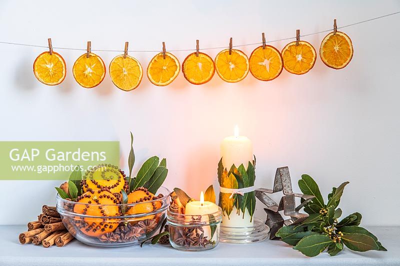 Shelf decorated with clove-studded oranges and Laurus nobilis - Bay - decorations, above orange slices pegged up on a line