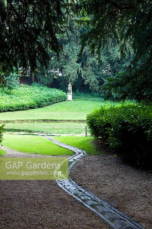 Rill flowing into pond, beyond a statute on plinth 