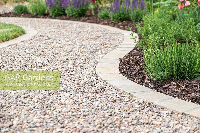 Curved gravel garden path with with 'Scottish Pebbles' gravel and edged with sandstone setts in 'Castle Grey'