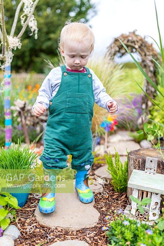 Young toddler walking through sensory garden