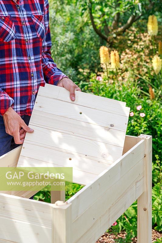 Inserting a wooden base into a planter built from a kit