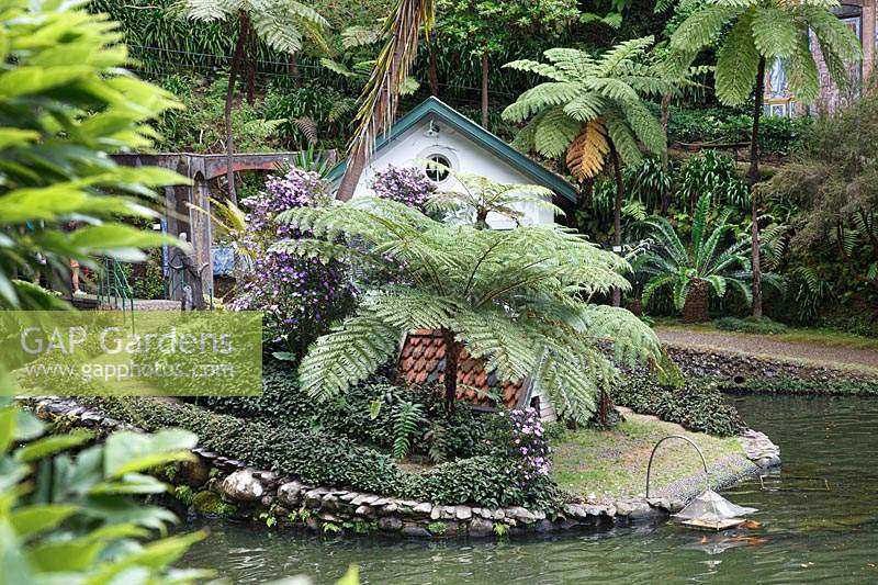 Decorative duck house near water in tropical garden 