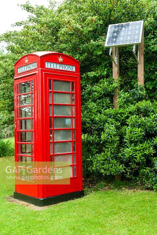 Restored GPO telephone kiosk on lawn with solar panel to power the lighting - Open Gardens Day, Coddenham, Suffolk