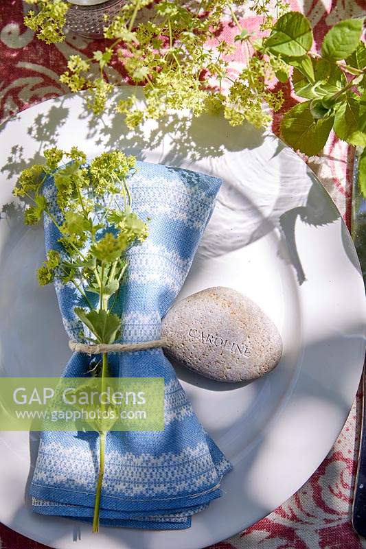 Table setting with fresh flowers, stone name tag and fabric napkins