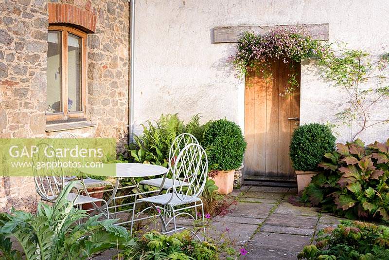 Modern garden furniture in courtyard garden at Am Brook Meadow, Devon in August. 