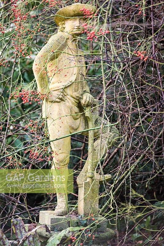 Statue of a gardener resting on his spade at the Old Rectory, Netherbury, UK. 