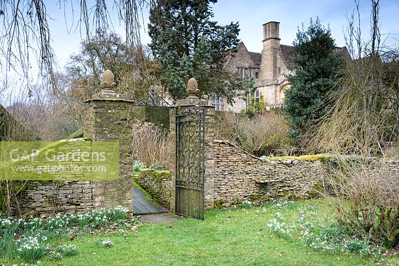 Gate with pineapple finials atop the gate posts, between the main garden and the Cherry Orchard at Rodmarton Manor, Glos, UK. 