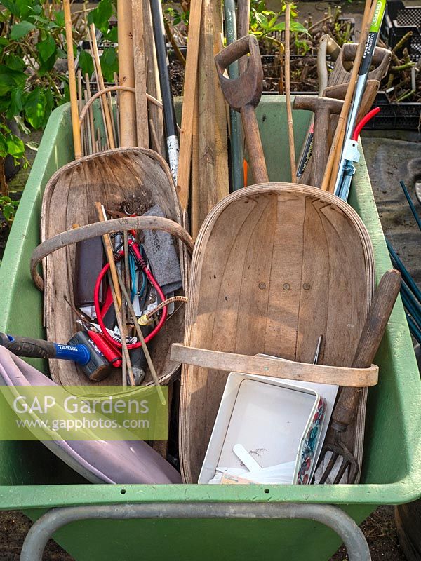 Wheelbarrow ready to garden. Trug, canes, tools, labels, kneeling pad, string.