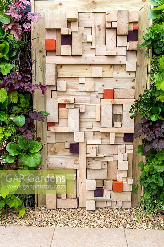 A vertical gardening living wall and modern wooden fence made from old timber cut offs. For The Love Of It, RHS Tatton Park Flower Show, 2017. garden Designer: Pip Prober