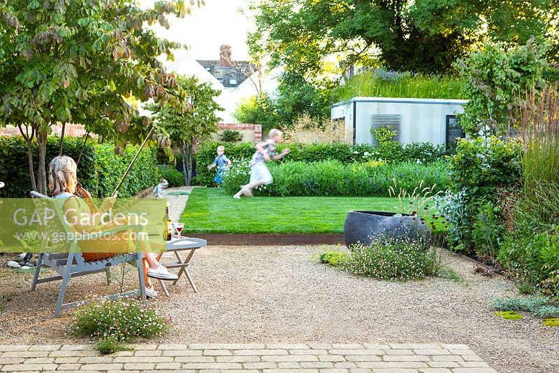 A family relaxing and playing in a contemporary city garden.