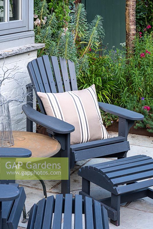 An Adirondack chair with matching footstool, painted in 'Iris' from Cuprinol Garden Shades.
