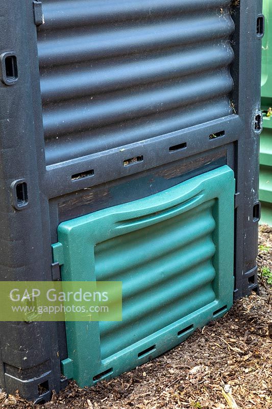 Flap on plastic compost bin for removing compost