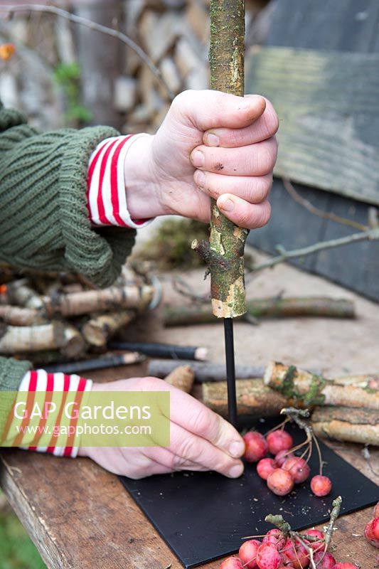 Woman fixing length of Birch with a hollow centre to metal stand. Styling: Marieke Nolsen. 