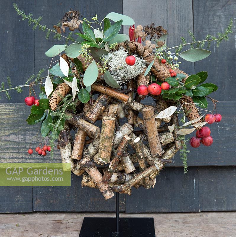 Wooden globe decorated with crab apples and evergreen foliage. Styling: Marieke Nolsen