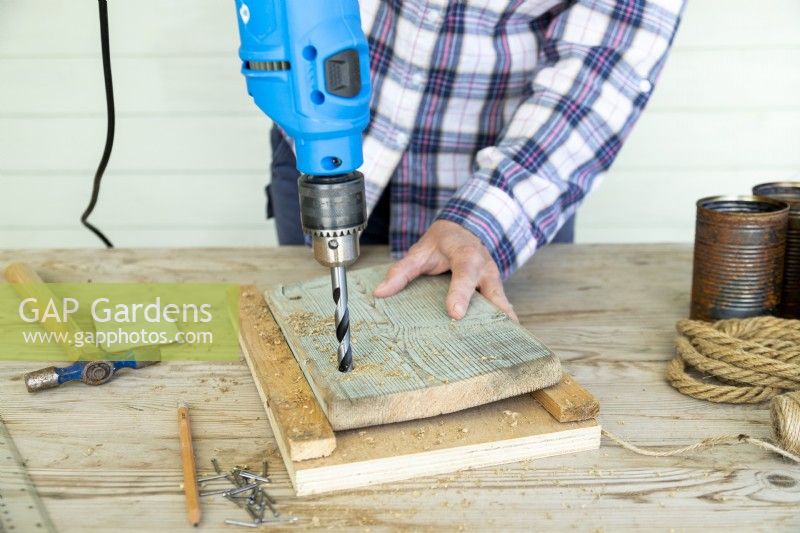 Woman drilling a hole in a woodden board