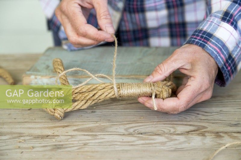 Woman wrapping string tightly around rope