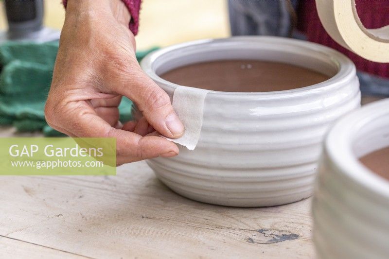 Placing masking tape over the edge of a pot
