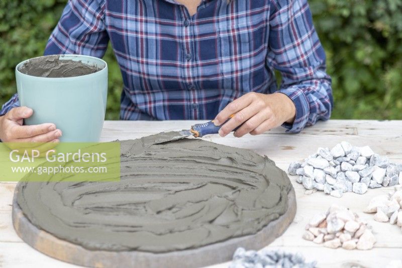 Spreading grout over the stepping stone