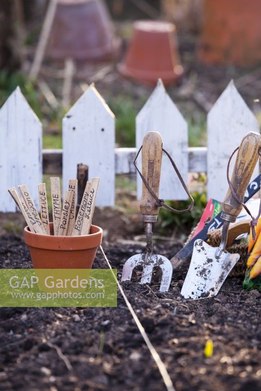 Garden line, hand tools and labels, ready to sow seed in a bed.