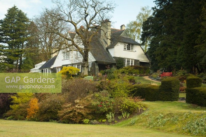 The Arts and Crafts style house at High Moss surrounded by herbaceous borders and trees including Quercus, Acer, Magnolia and Rhododendron