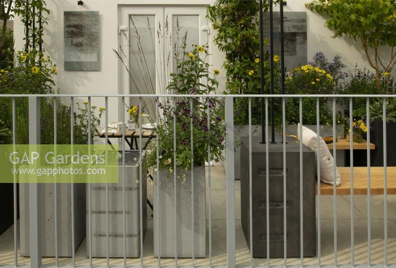 Metal containers full of perennials in the Landform Balcony Garden.