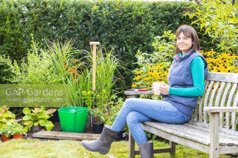 Woman sitting on bench next to workspace