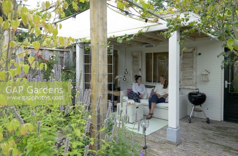Relaxing in the summer house under the grape pergola.