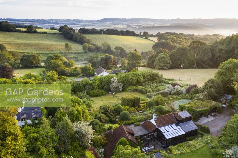 View over whole garden and out to countryside; image taken with drone. July. Summer.