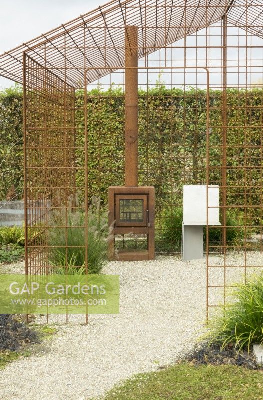 Corten stove in house frame of corten steel grid.