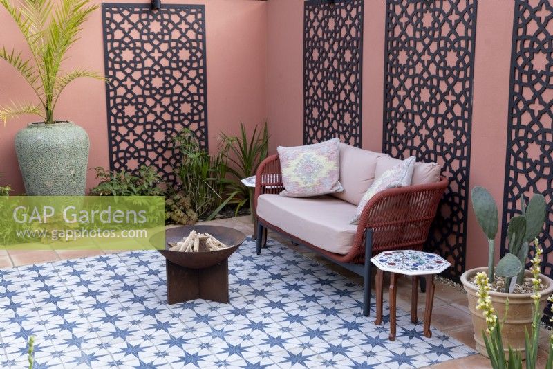 Moroccan style patio in suburban garden with decorative screens on painted wall
