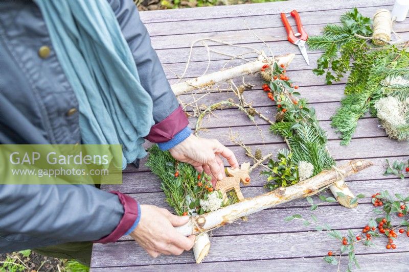 Woman adding wooden reindeer to the frame