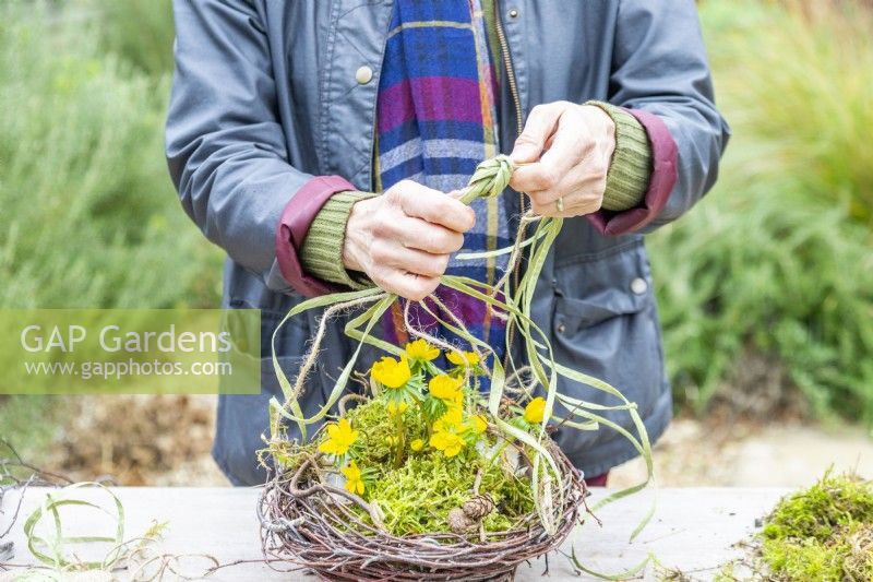 Woman tying the raffia and string together