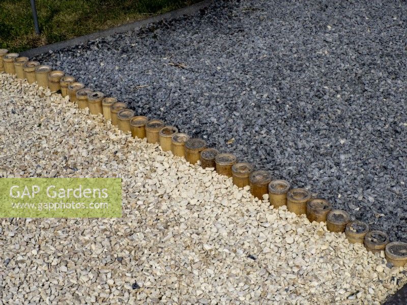 Edging detail of thick stemmed bamboo tubes separating two colours of gravel pathway . Floriade Expo 2022 International Horticultural Exhibition Almere Netherlands