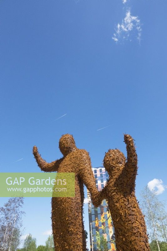 Two giant figures covered with 10,000 bees made of Corten steel designed by Florentijn Hofman named Beehold.