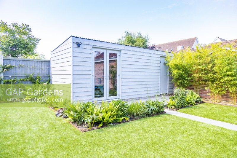 Large garden shed aurrounded by plant bedding