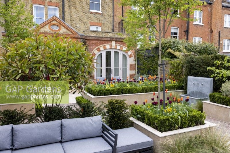 Suburban garden in spring - seating area in contemporary suburban garden, with views towards house