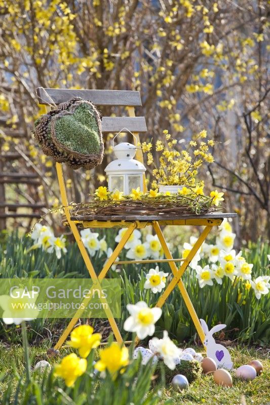 Spring arrangement with wreath of willow twigs, daffodils, hanging moss heart and Easter eggs.