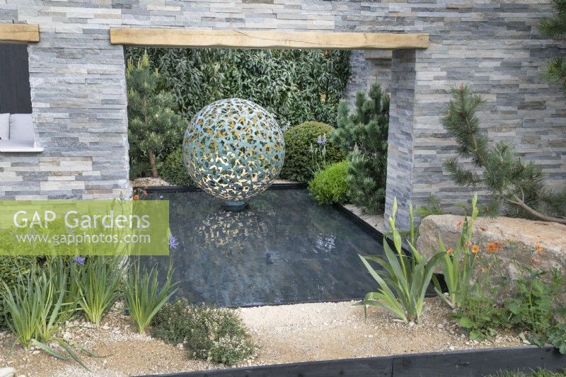 Water feature surrounded by stone walls in A Peaceful Escape at RHS Malvern Spring Festival 2022