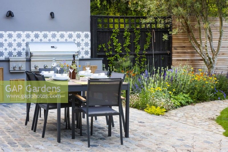 Table set up for a dinner by outdoor kitchen. 