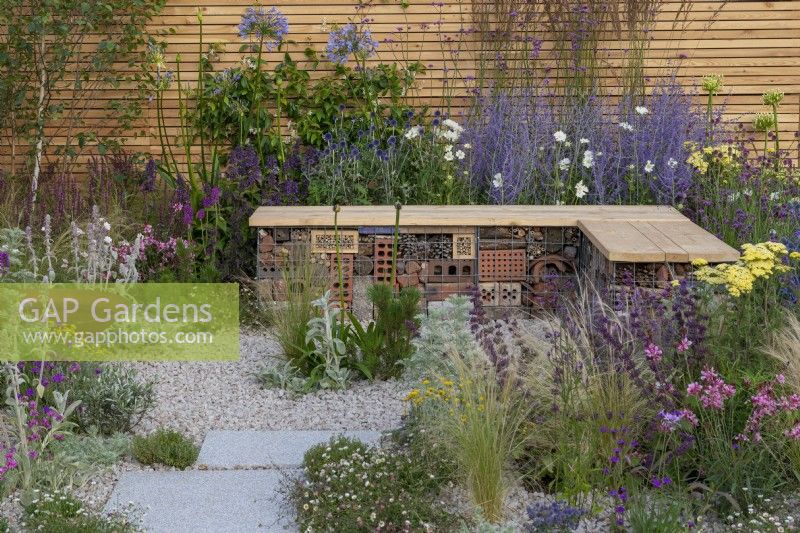 A sustainable, low maintenance gravel garden filled with drought tolerant plants to attract pollinators, such as salvia, achillea, sea pinks, echinops, fleabane, perovskia, gaura, drumstick allium and catmint. Turfed Out Garden. Design: Hamzah-Adam Desai.