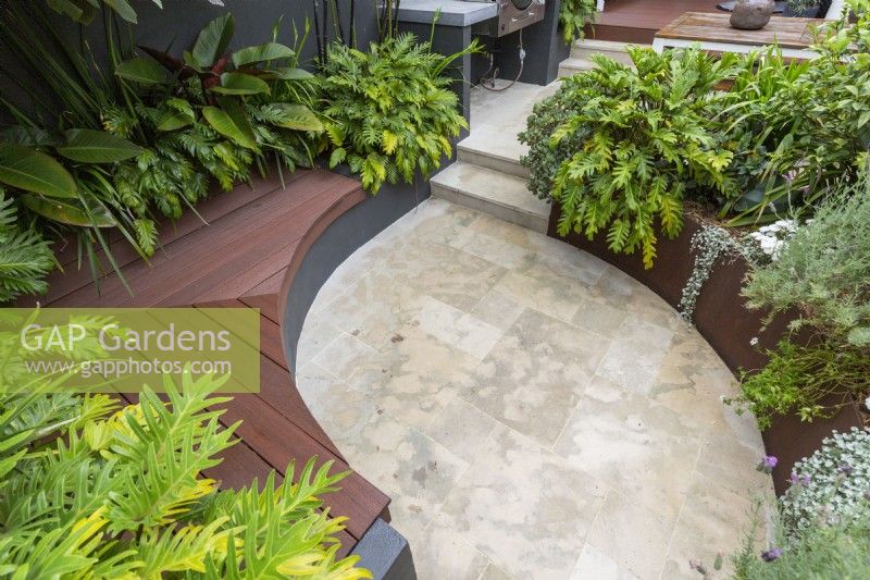 Overhead view of an inner city courtyard garden with inbuilt curved composite timber bench seating.