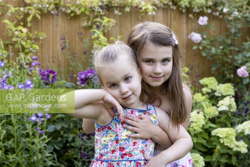 Two young girls playing in a garden