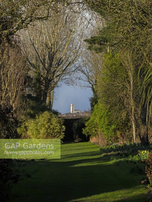 View of Happisburgh church from the Apple walk East Ruston Old Vicarage gardens Norfolk March Spring