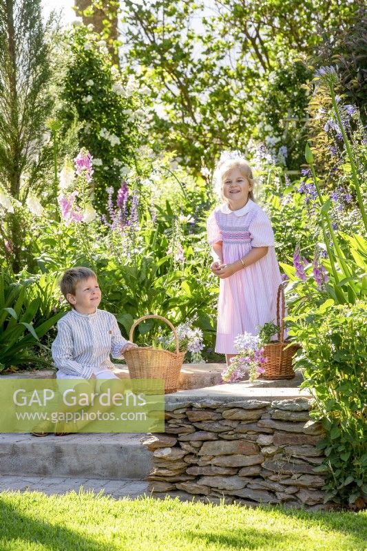 Boy and girl picking flowers in a garden