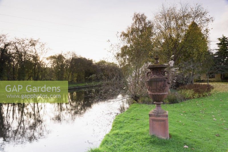 Terracotta urn beside the canal that borders John Massey's garden in October.